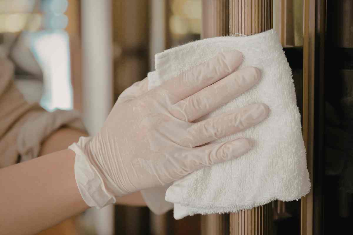 persona pulisce la cucina con i guanti